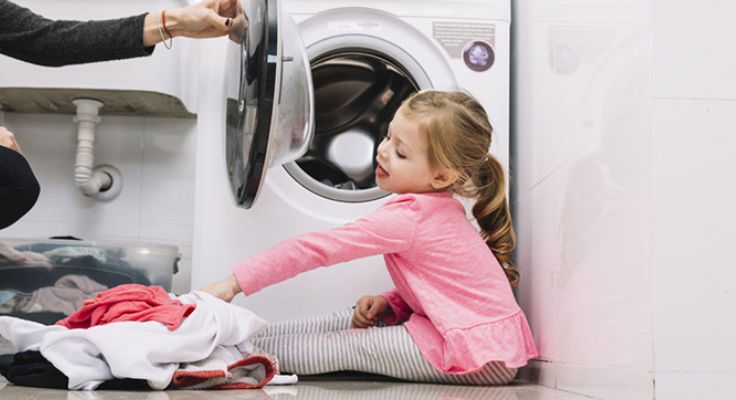 Petite fille dans la laverie du camping