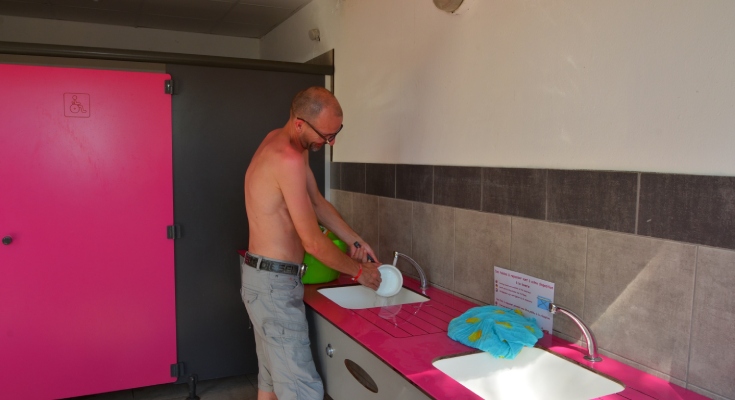 Vacancier aux bacs vaisselles des sanitaires